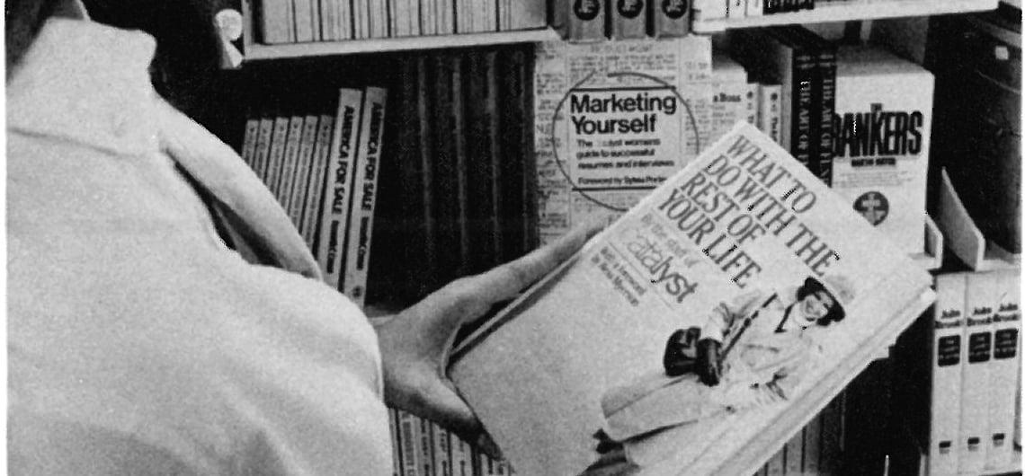 Crop of a marketing photo of a woman holding a book of "What to do with the rest of your life" by Catalyst